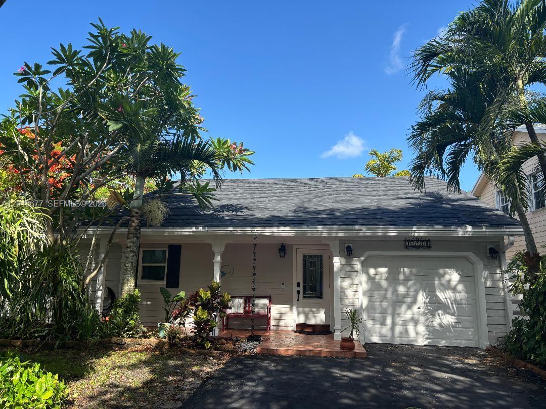 A single-story house with a white garage, front porch, and palm trees under a blue sky — 15110 SW 141st Ct, Miami FL 33186, MIAMI, FL