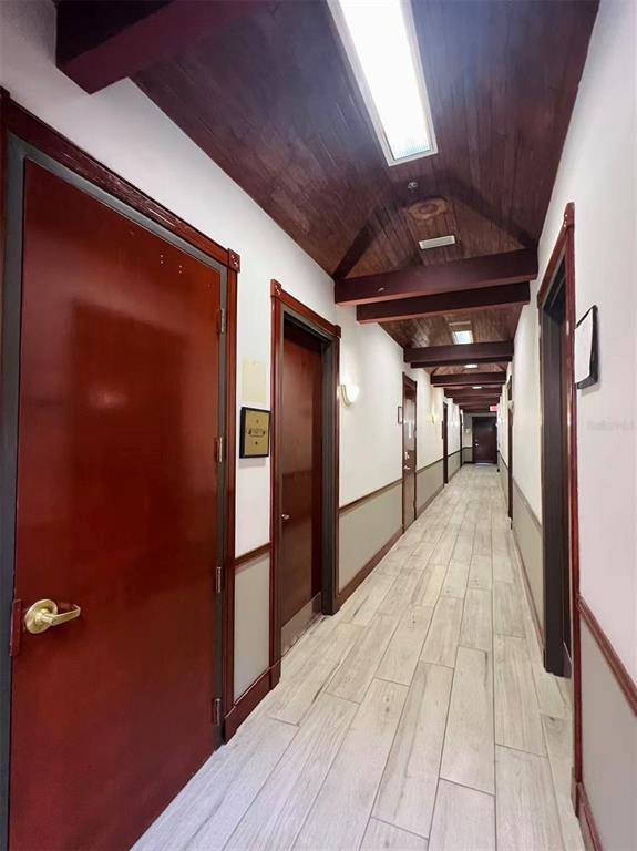 A long hallway features wood-paneled ceilings, light-colored tile flooring, and several dark wood doors — 2500 W LAKE MARY BOULEVARD UNIT 213, LAKE MARY, FL