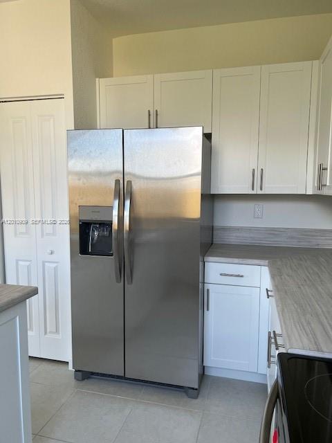 A stainless steel refrigerator stands in a kitchen with white cabinets and light-colored countertops — 13102 SW 232nd Ln # 13102, Miami FL 33032, MIAMI, FL