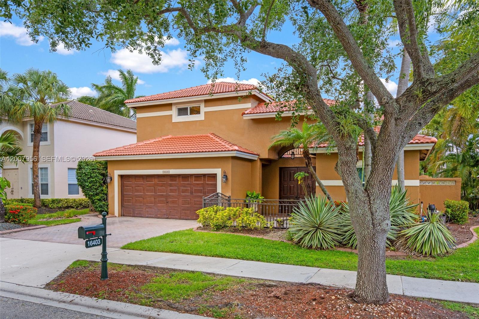A two-story stucco house with a tile roof and a two-car garage — 16403 Diamond Head Dr, Weston FL 33331, WESTON, FL