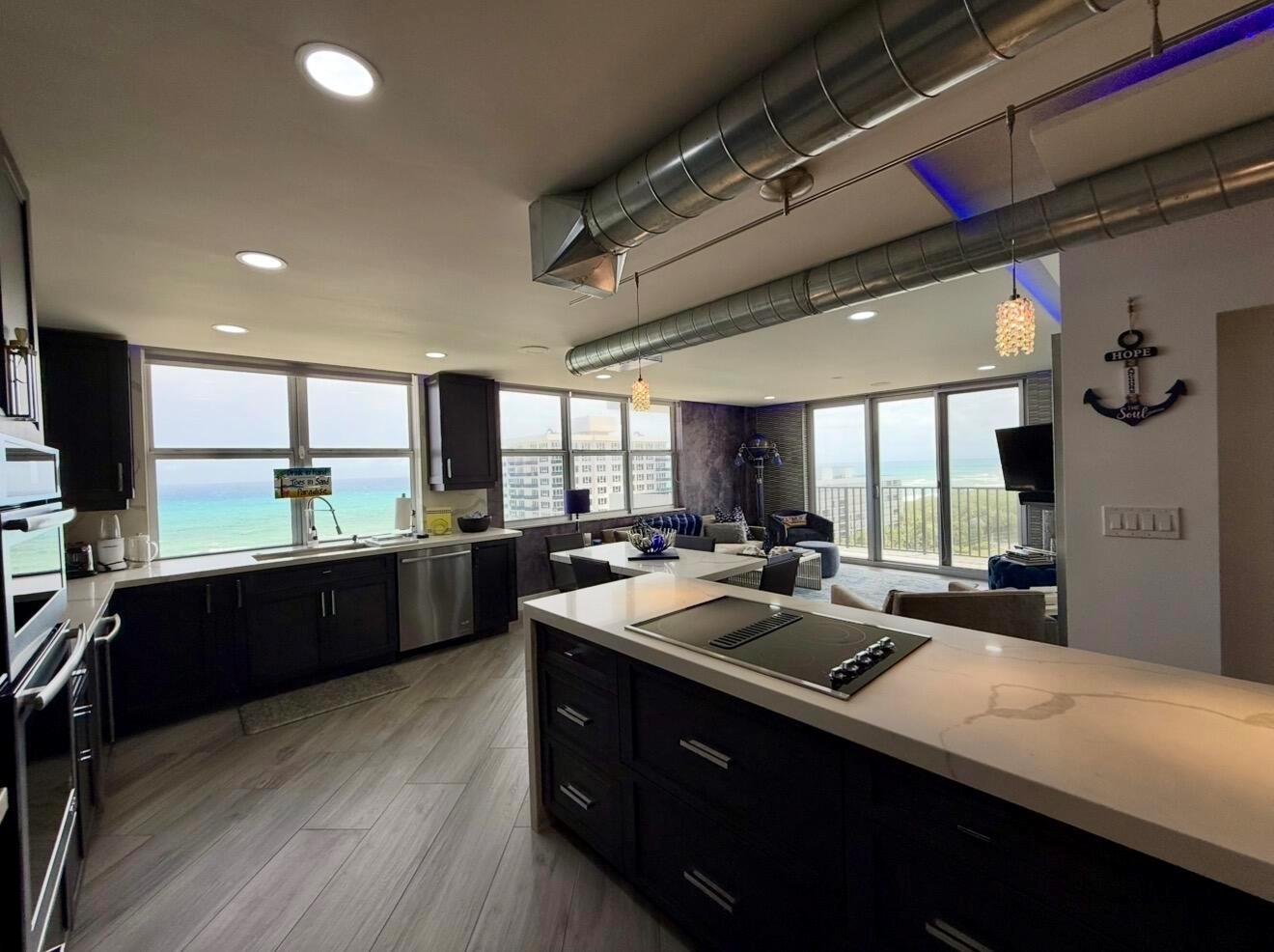 A modern kitchen with dark cabinetry and a large island overlooks the ocean — 2121 N Ocean Boulevard # 1409e, Boca Raton FL 33431, BOCA RATON, FL