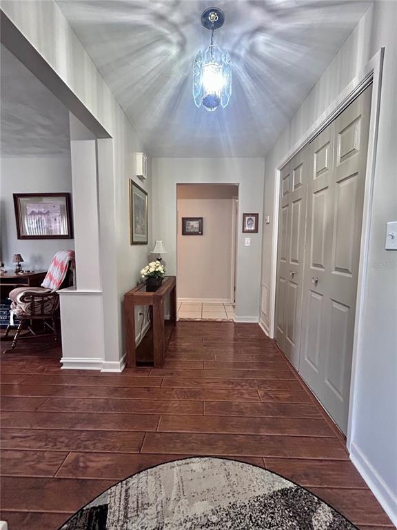 A hallway with wood-look tile flooring leads to an open doorway and a closet — 1826 6TH STREET SE, WINTER HAVEN, FL