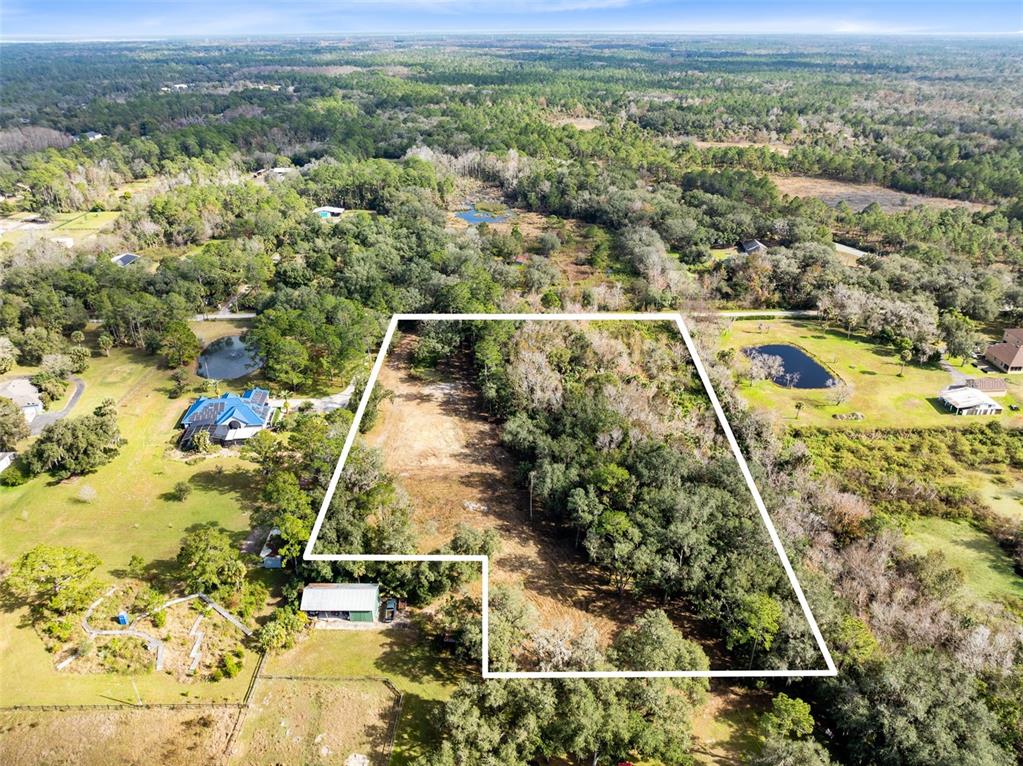 An aerial view shows a large, partially wooded plot of land outlined in white — 1630 MURPHY STREET, OVIEDO, FL