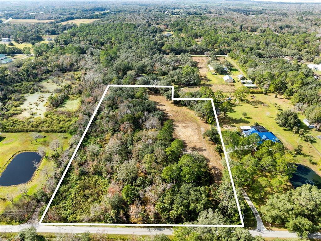An aerial view shows a rectangular plot of land outlined in white with dense vegetation — 1630 MURPHY STREET, OVIEDO, FL