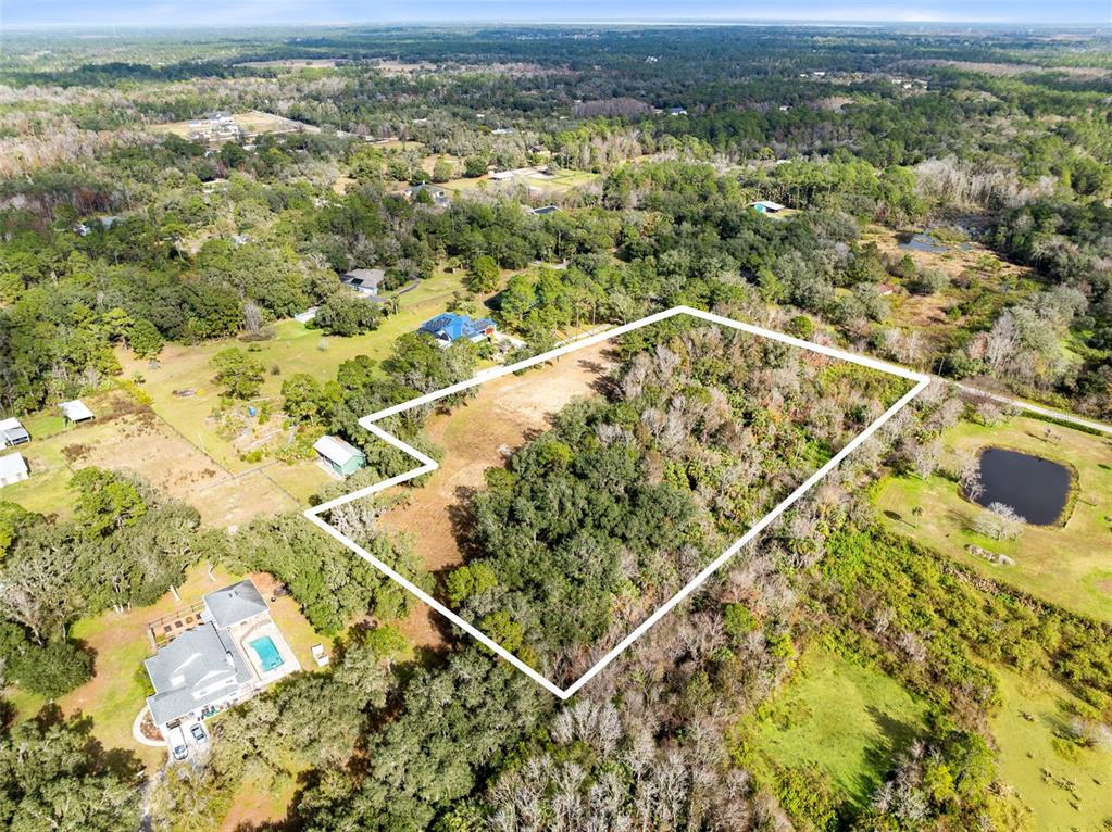 An aerial view shows a wooded residential lot outlined in white near a house — 1630 MURPHY STREET, OVIEDO, FL