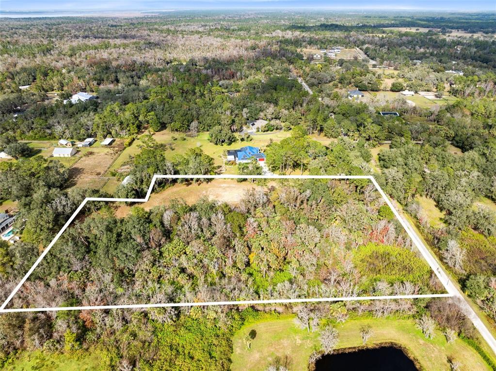 An aerial view shows a wooded plot of land outlined in white near a house — 1630 MURPHY STREET, OVIEDO, FL