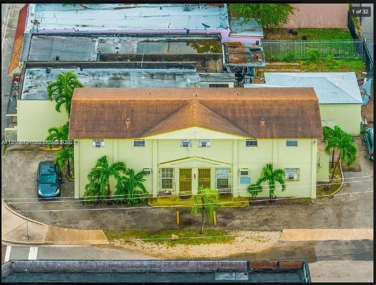 An aerial view shows a two-story, light-yellow apartment building with a brown shingled roof — 1500 NW 69th Ter, Miami FL 33147, MIAMI, FL