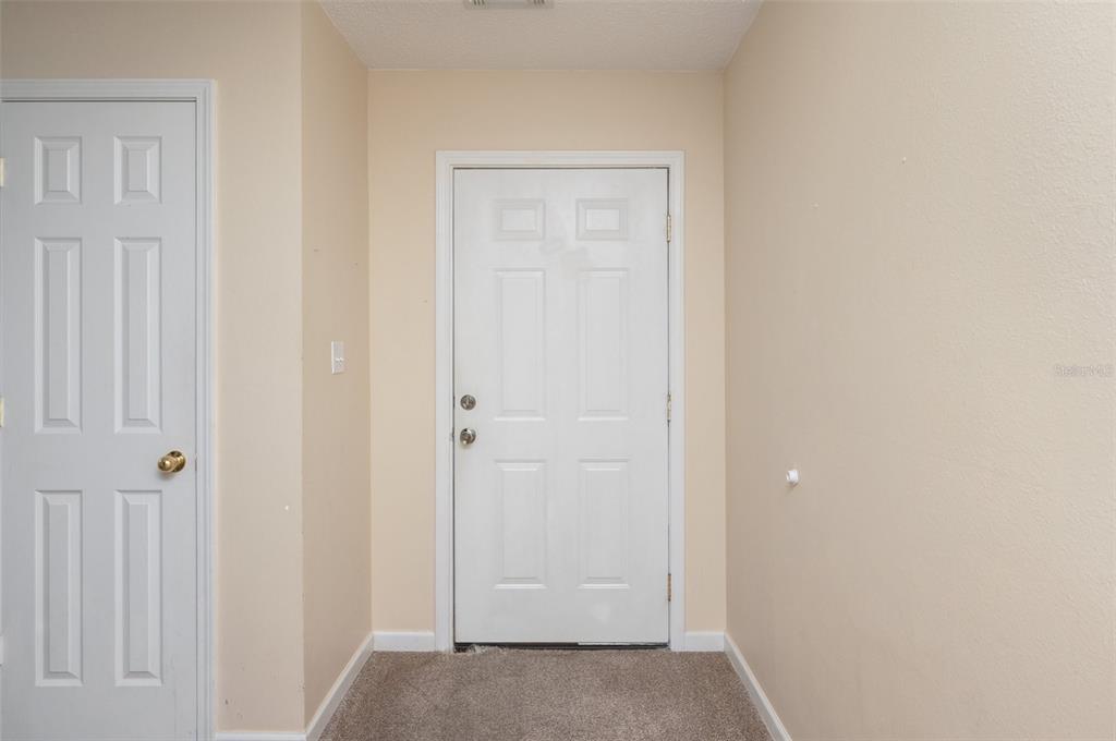 An interior view of an entryway featuring a white front door and a closet door — 307 CROOKED PINE TRAIL, CRESTVIEW, FL