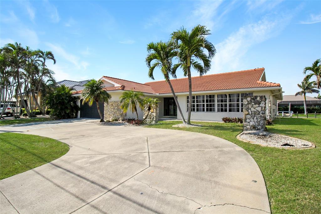 A single-story house with a tile roof, stone accents, and a large concrete driveway — 945 BAL HARBOR BOULEVARD, PUNTA GORDA, FL