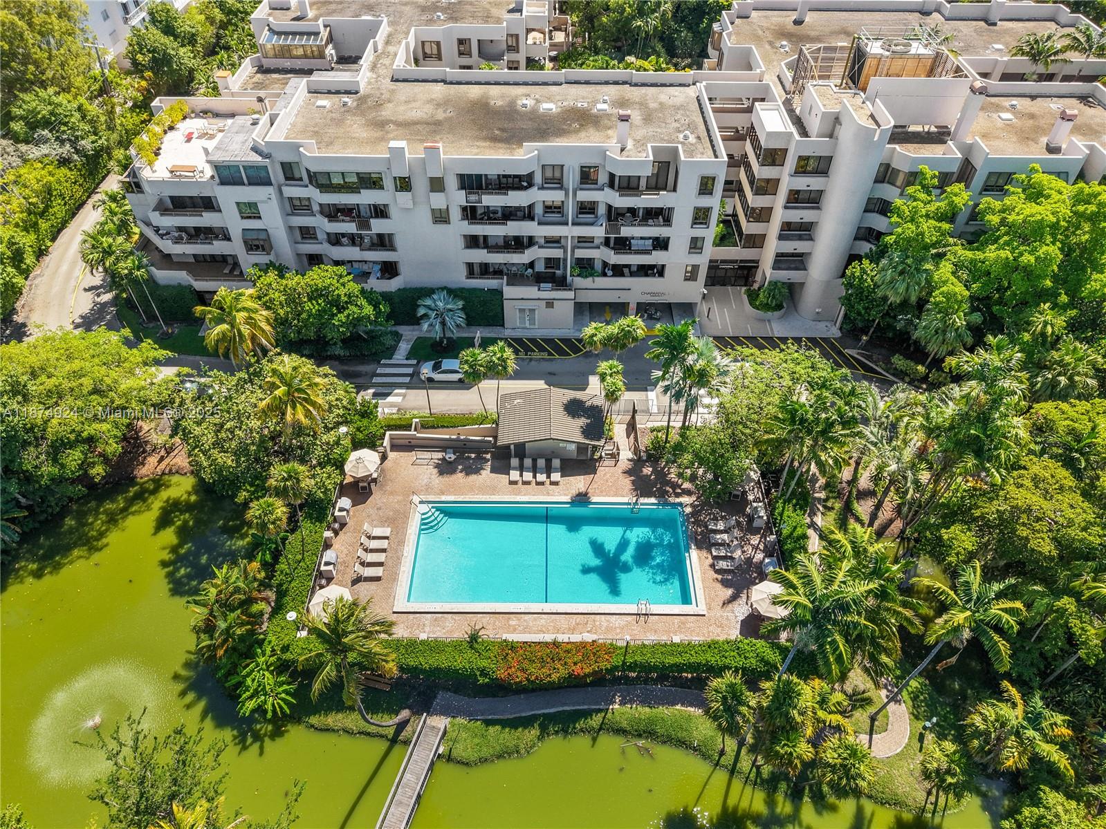 An aerial view shows a multi-story apartment building with a swimming pool and pond — 101 Crandon Blvd # 381, Key Biscayne FL 33149, KEY BISCAYNE, FL