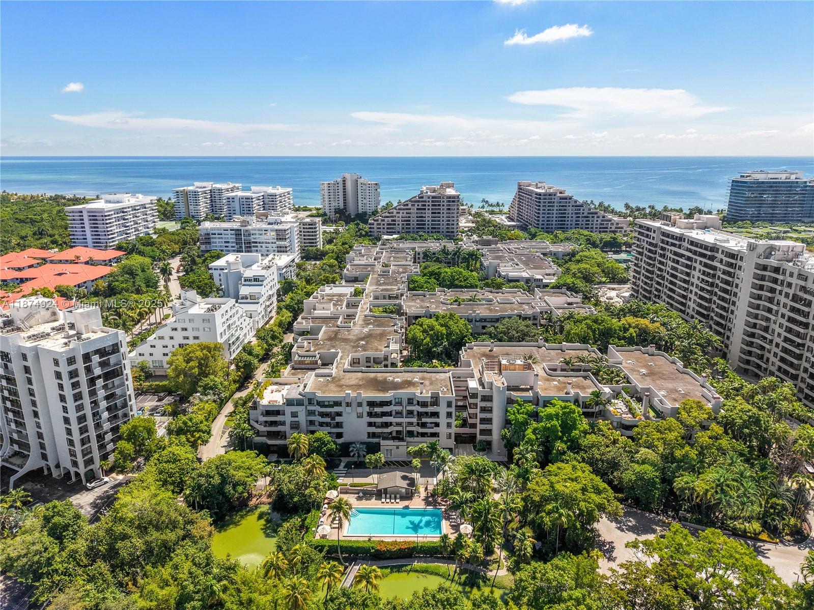 An aerial view shows a multi-story residential complex with a swimming pool and lush landscaping — 101 Crandon Blvd # 381, Key Biscayne FL 33149, KEY BISCAYNE, FL