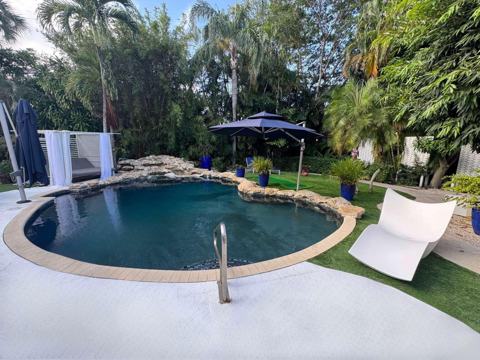 An outdoor patio features a shower panel, two white chairs, and a wooden sauna door — 233 Pershing Way, West Palm Beach FL 33401, WEST PALM BEACH, FL