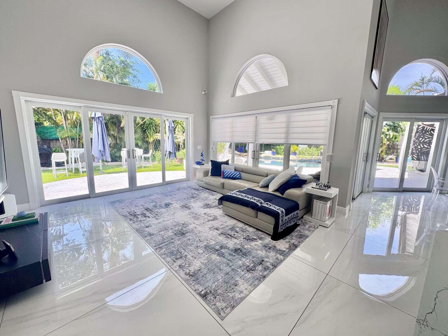 A modern walk-in shower features a built-in bench, pebble flooring, and a rainfall showerhead — 233 Pershing Way, West Palm Beach FL 33401, WEST PALM BEACH, FL