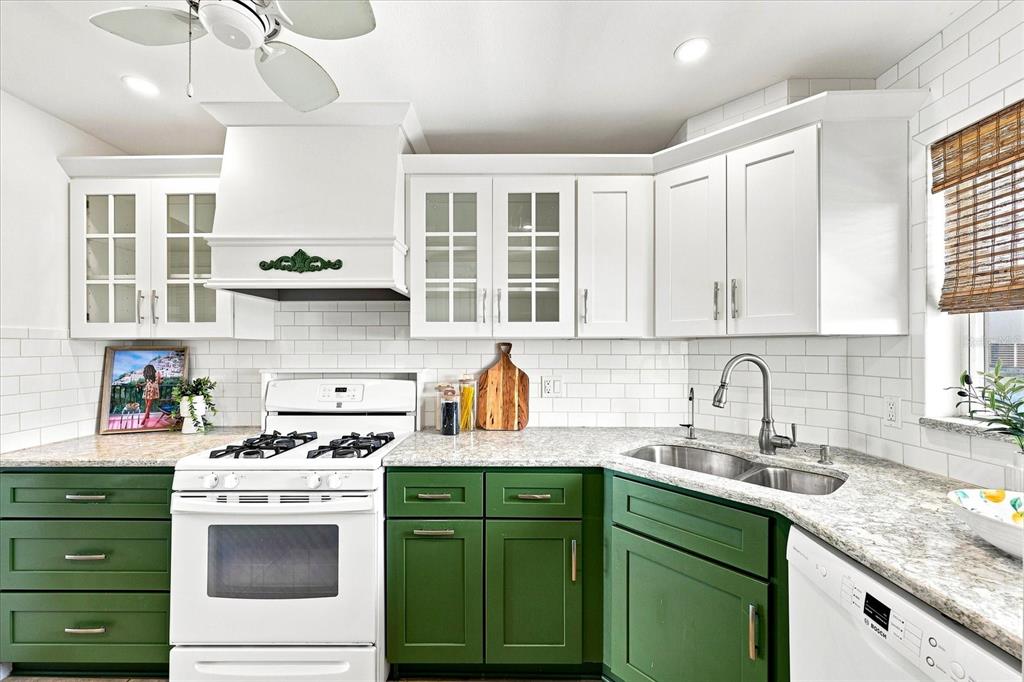 A kitchen features white upper cabinets, green lower cabinets, white appliances, and granite countertops — 6020 SHORE BOULEVARD S UNIT 1002, GULFPORT, FL