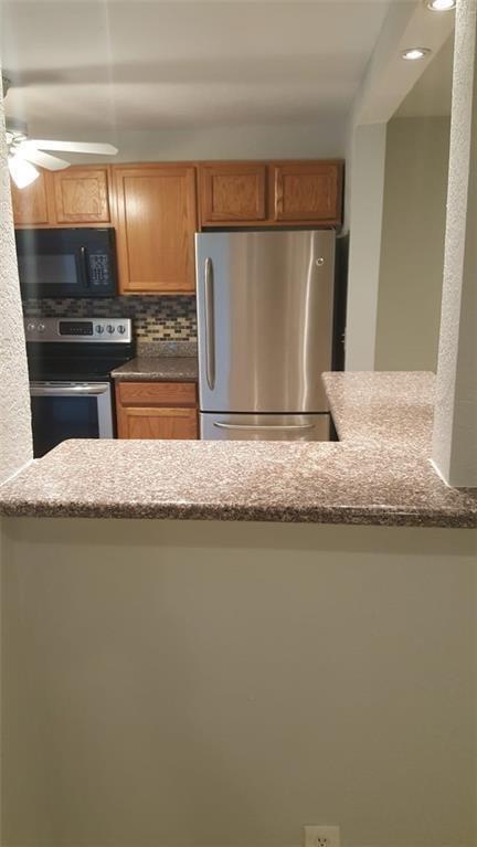 A kitchen with oak cabinets, stainless steel appliances, and a granite-topped breakfast bar — 180 NE 12th Avenue # 17a, Hallandale Beach FL 33009, HALLANDALE BEACH, FL