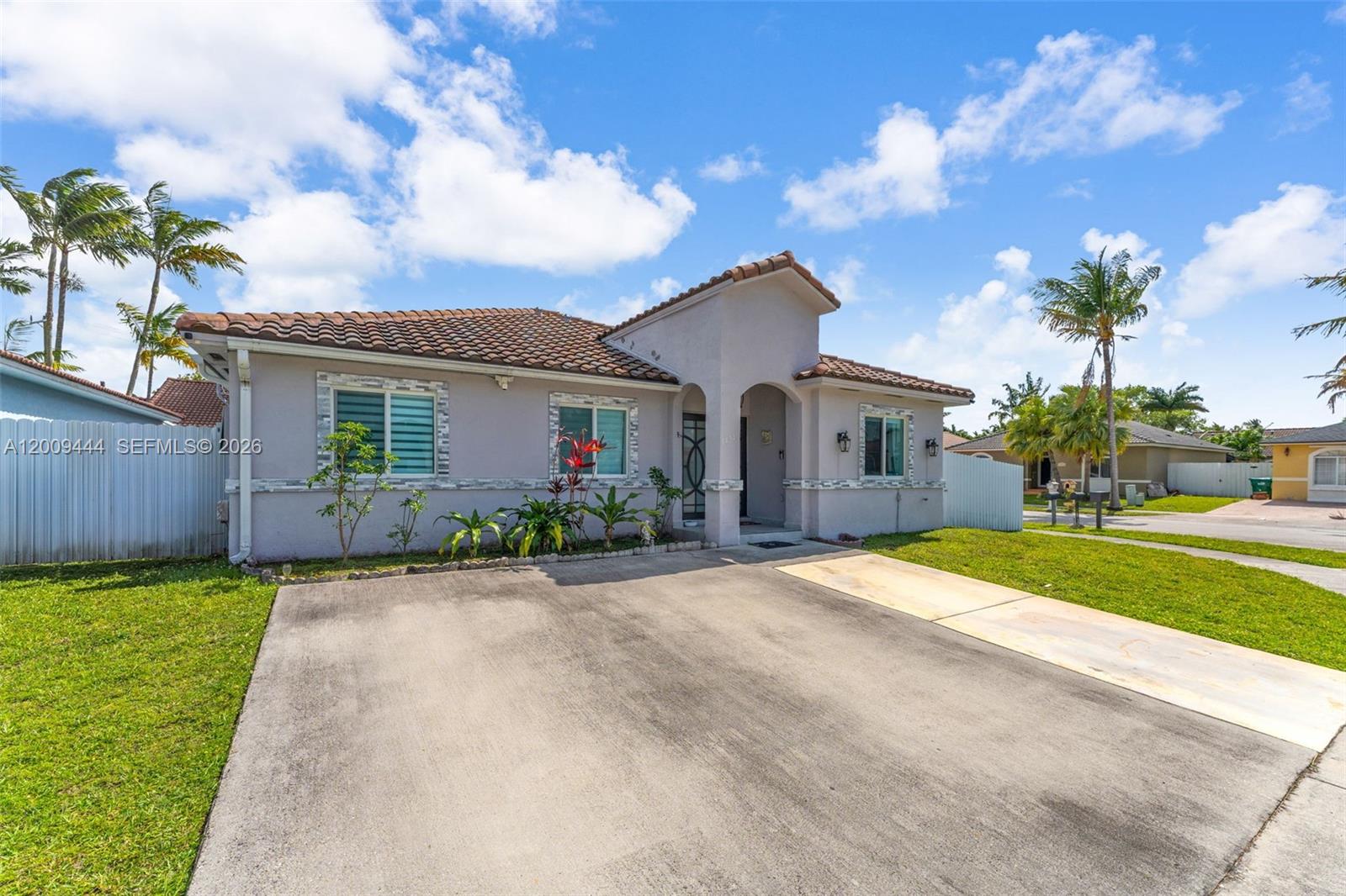 A single-story house with a tiled roof, light-colored stucco walls, and a concrete driveway — 14240 SW 171st St, Miami FL 33177, MIAMI, FL