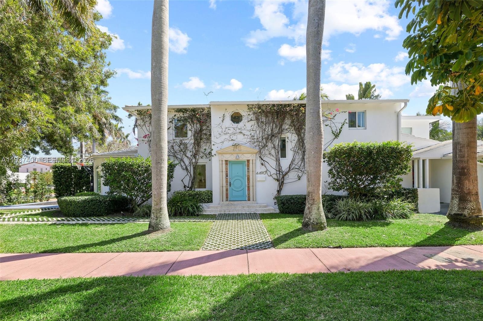 A two-story white house features a bright blue front door and two tall palm trees — 4490 Royal Palm Ave, Miami Beach FL 33140, MIAMI BEACH, FL