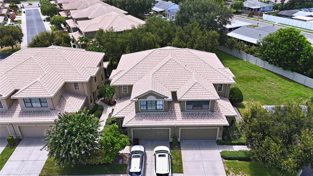 An aerial view of a two-story residential building with a tiled roof and attached garages — 7974 TASSO COURT, SEMINOLE, FL