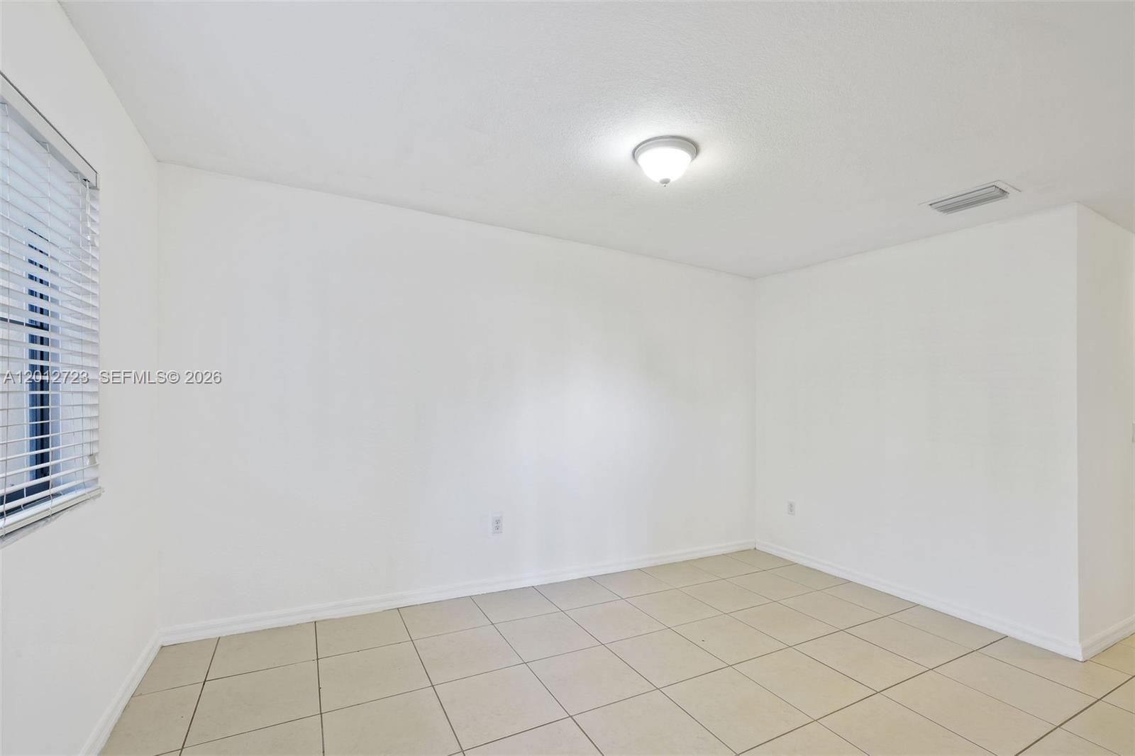 An empty room with white walls, tiled flooring, a window with blinds, and ceiling lighting — 11238 SW 187th St # 11238, Miami FL 33157, MIAMI, FL