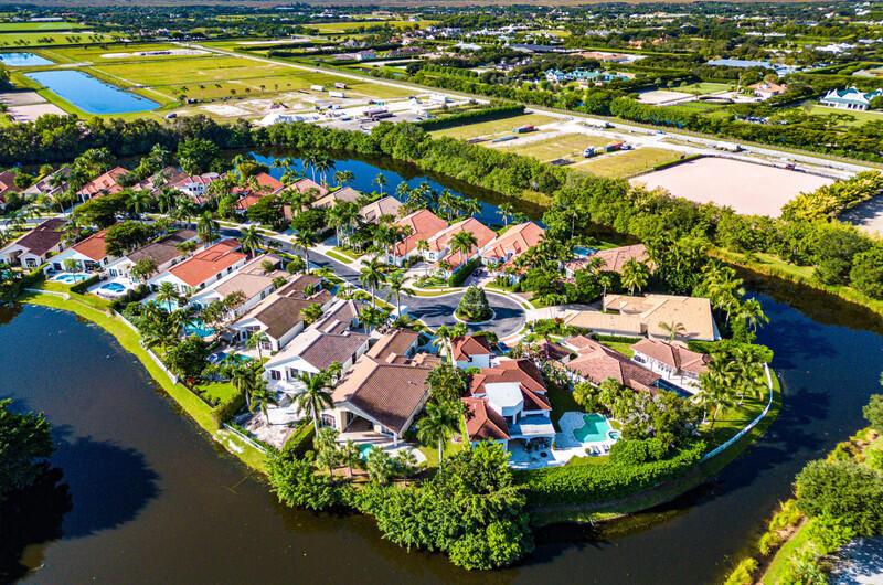 An aerial view of a residential neighborhood with houses surrounding a central cul-de-sac and lake — 14364 Stroller Way, Wellington FL 33414, WELLINGTON, FL