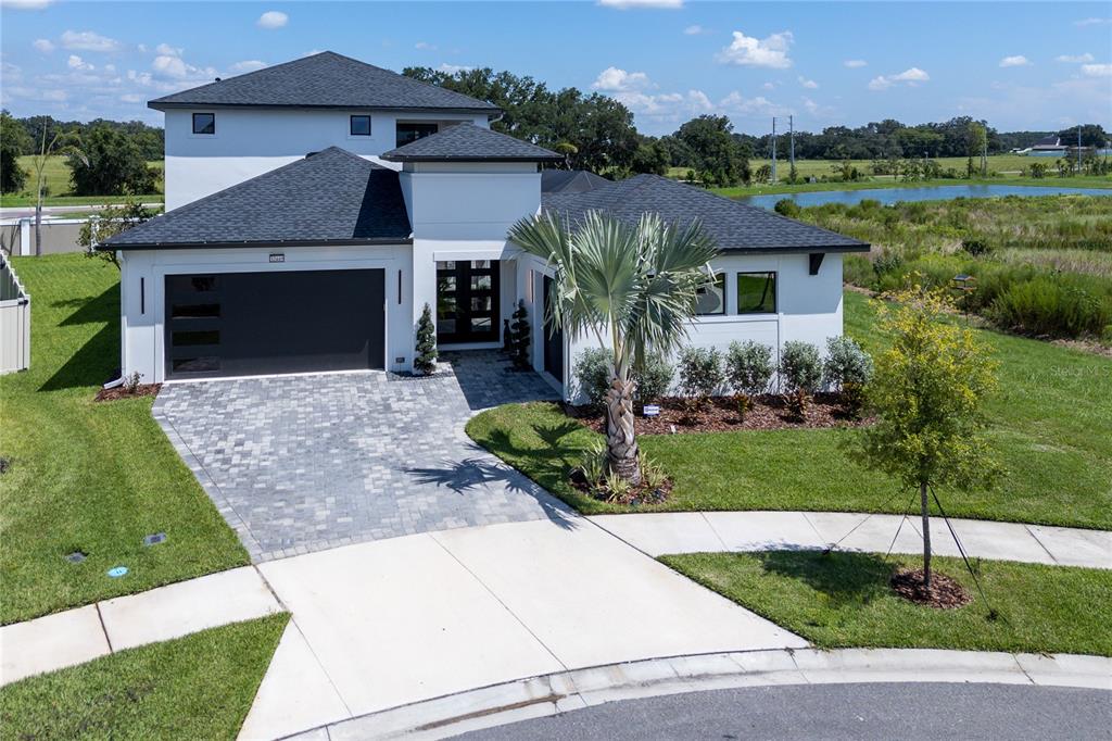 An aerial view of a modern two-story house with a paved driveway and palm tree — 32449 WETLAND BIRD VIEW, SAN ANTONIO, FL