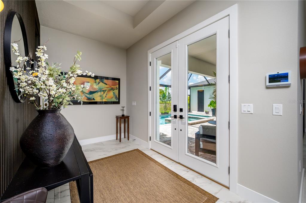 An entryway with white marble floors, a console table, and glass doors opening to a pool — 32449 WETLAND BIRD VIEW, SAN ANTONIO, FL