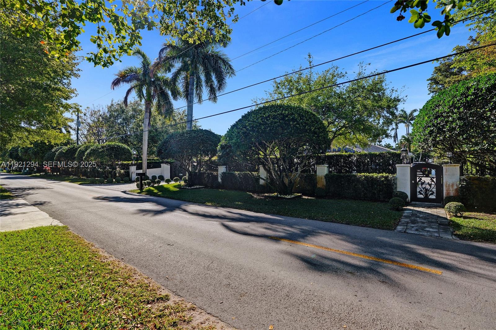 A paved road leads to a gated entrance surrounded by lush trees and manicured hedges — 10400 SW 62nd St, Miami FL 33173, MIAMI, FL