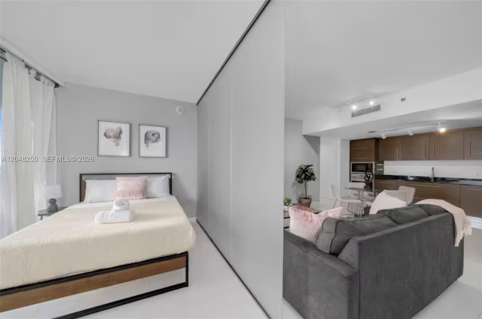 A studio apartment features a bed separated from the living area by a sliding partition — 485 Brickell Ave # 1901, Miami FL 33131, MIAMI, FL