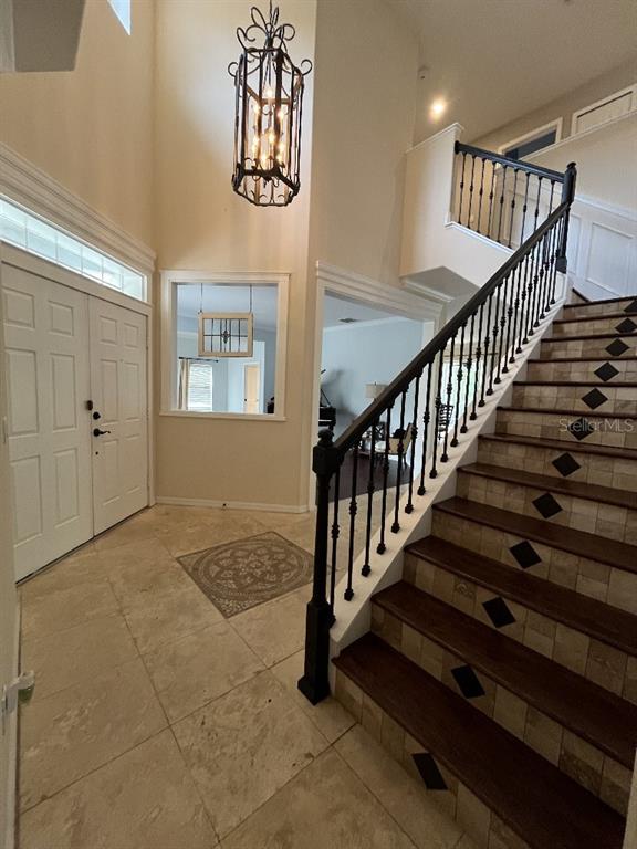 An entryway features a tiled staircase with dark wood treads, a chandelier, and double doors — 5879 LAKE MELROSE DRIVE, ORLANDO, FL