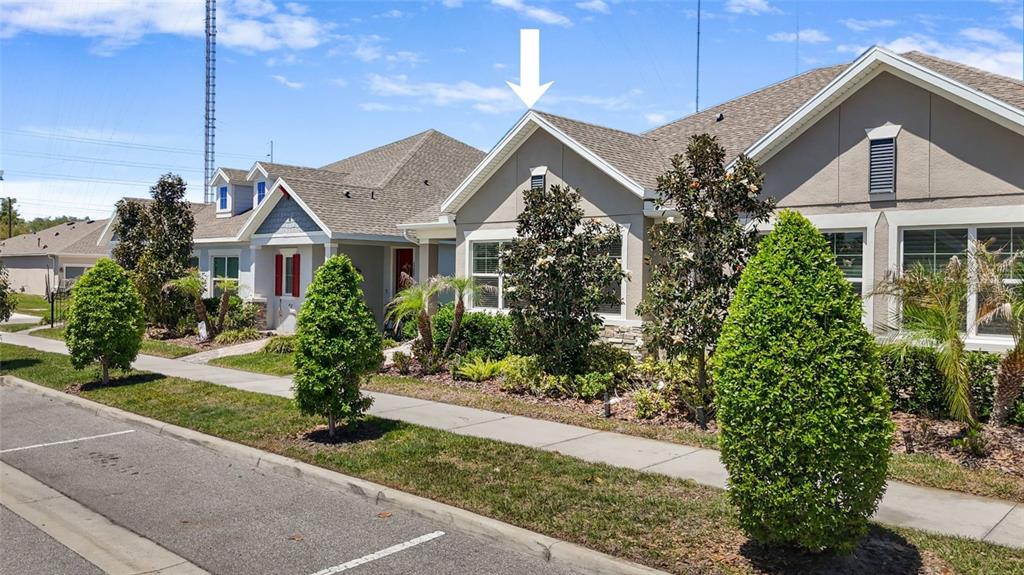 A street-level view of a suburban house with a gabled roof and landscaped front yard — 13890 KINGFISHER GLEN DRIVE, LITHIA, FL