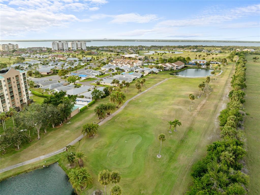 An aerial view shows a golf course fairway adjacent to residential buildings and a lake — 2320 TERRA CEIA BAY BOULEVARD UNIT 206, PALMETTO, FL