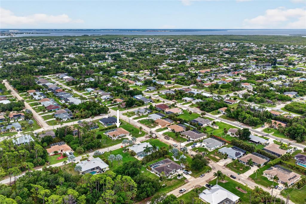 An aerial view shows a residential neighborhood with a white arrow pointing to a house — 4236 FENWAY STREET, PORT CHARLOTTE, FL