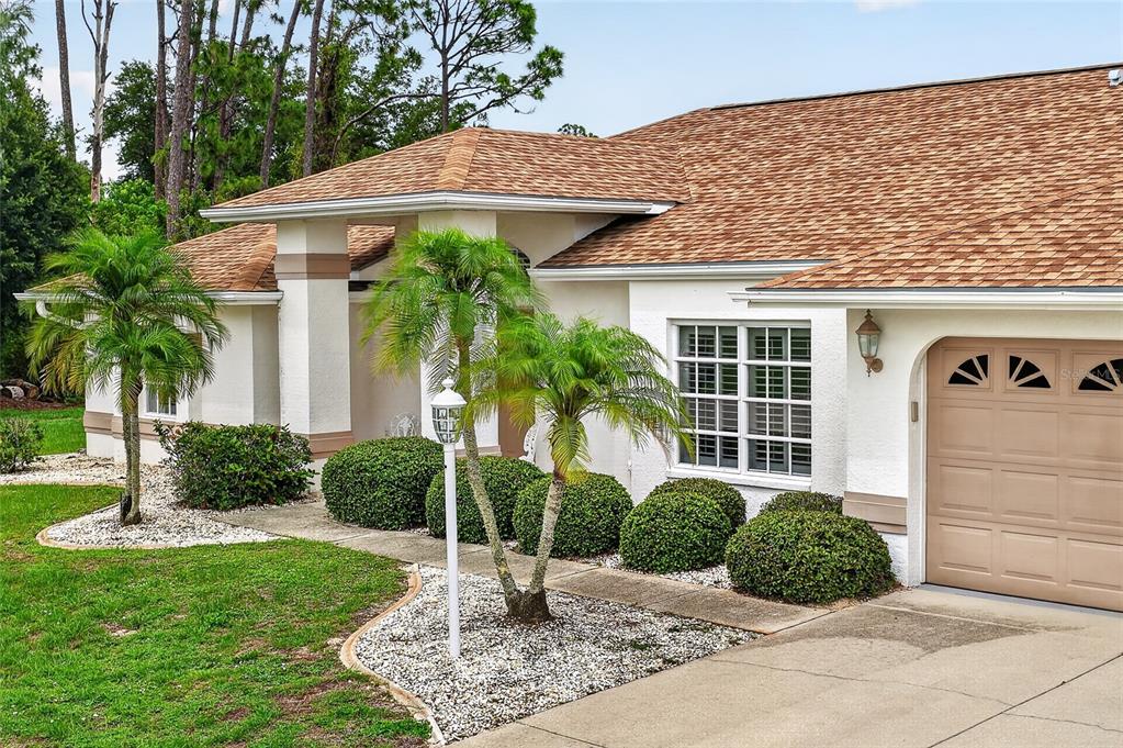 A single-story house with a tan garage door, white stucco walls, and two palm trees — 4236 FENWAY STREET, PORT CHARLOTTE, FL