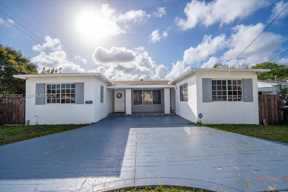 A single-story house with a white exterior, gray shutters, and a paved driveway — 740 SW 7th Ave, Hallandale Beach FL 33009, HALLANDALE BEACH, FL