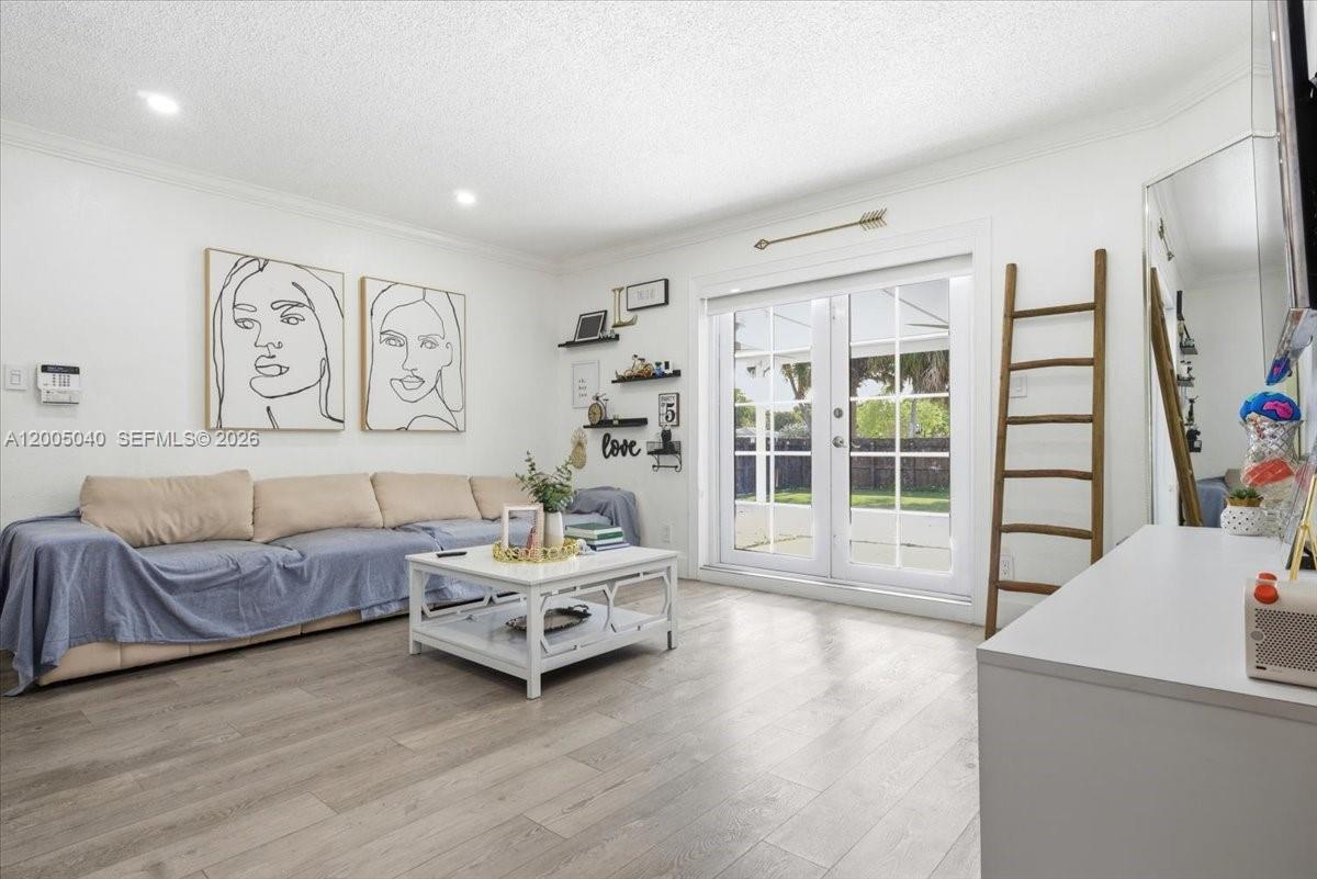A living room features a beige sofa, white coffee table, wall art, and glass doors — 740 SW 7th Ave, Hallandale Beach FL 33009, HALLANDALE BEACH, FL