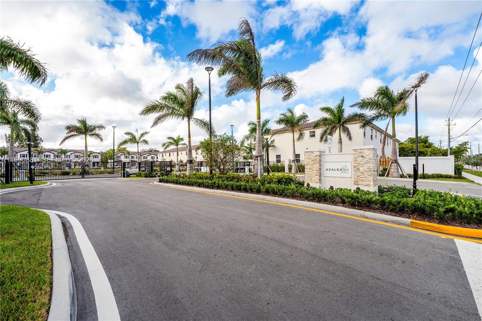 The entrance to a gated residential community features palm trees and a stone monument sign — 5514 NW 27th St, Lauderhill FL 33313, LAUDERHILL, FL