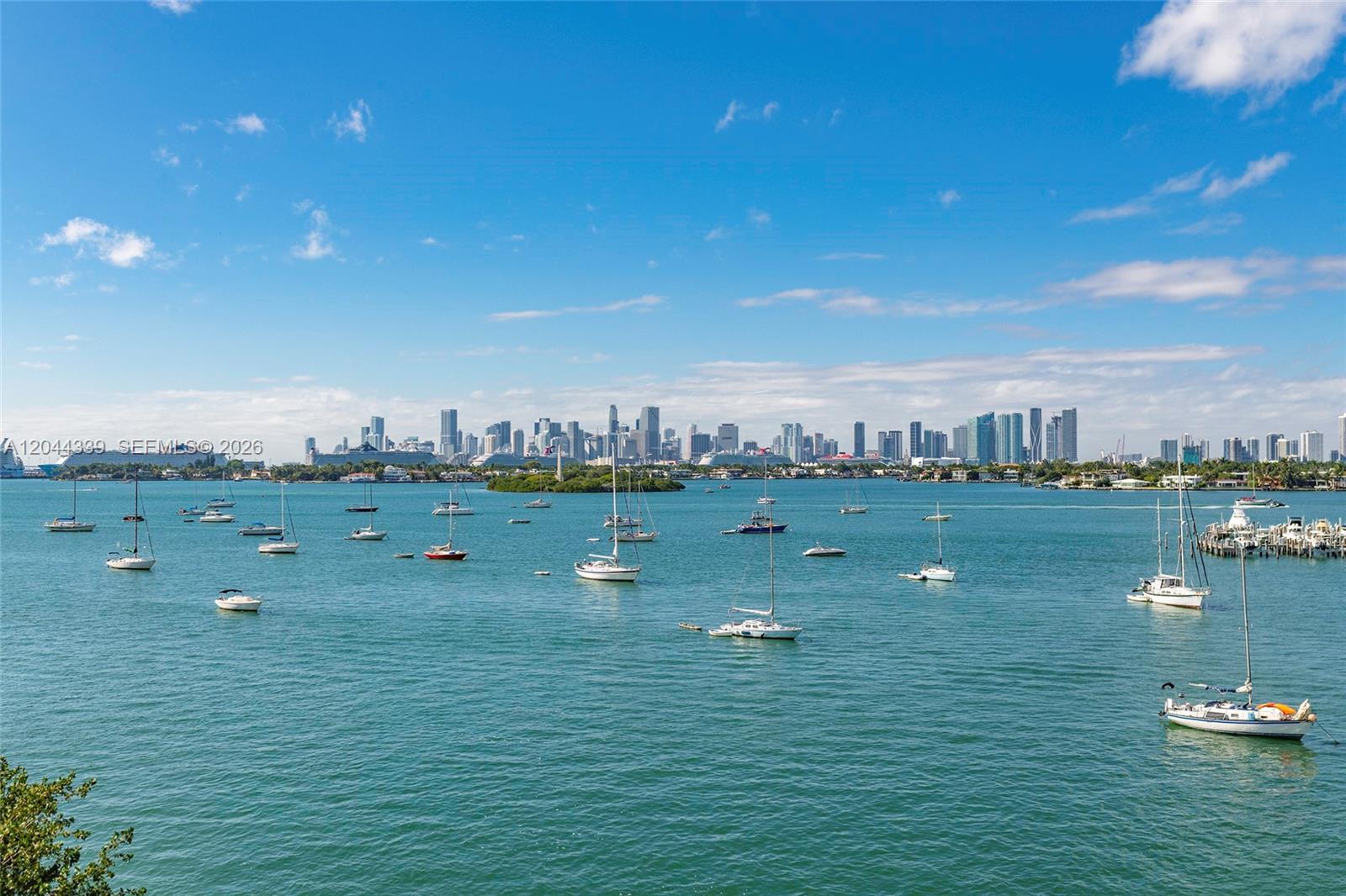 A view of a bay filled with sailboats and yachts against a distant city skyline — 1470 16th St # 401, Miami Beach FL 33139, MIAMI BEACH, FL