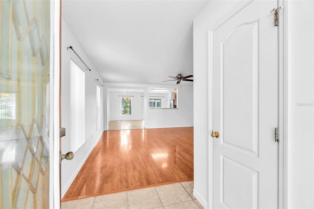 An entryway with tile flooring leads into a living area with hardwood floors and ceiling fan — 6760 WATERTON DRIVE, RIVERVIEW, FL
