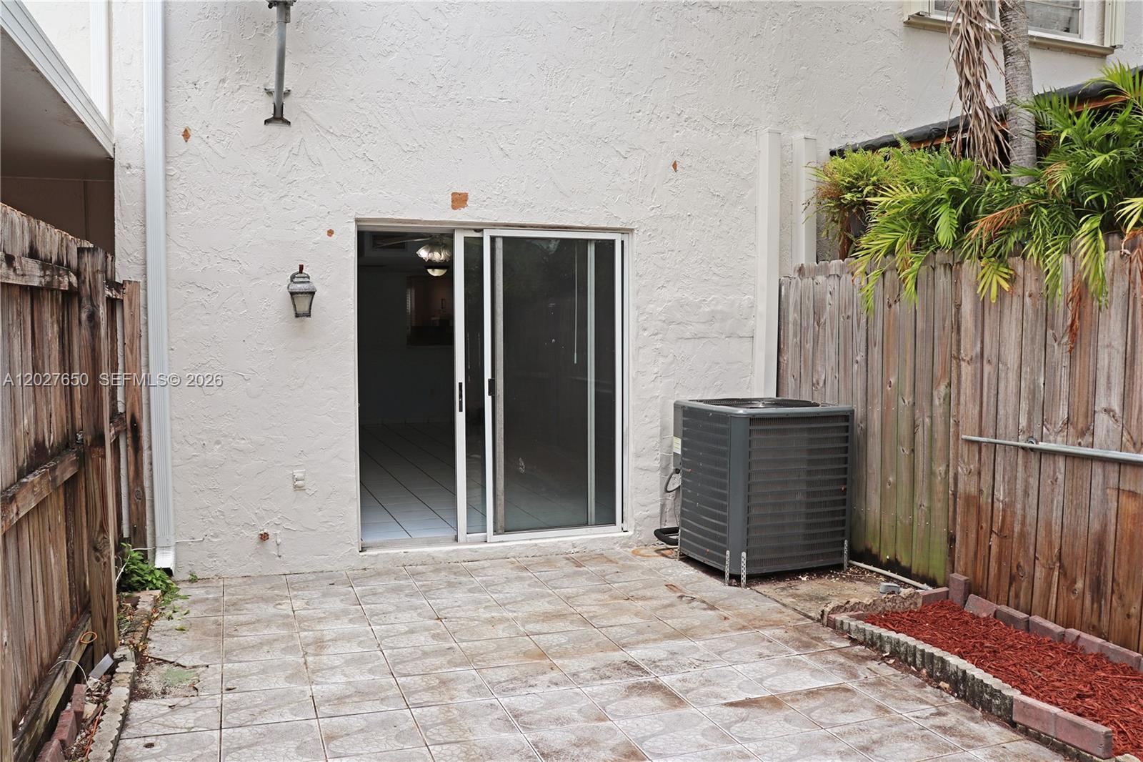 A patio with tiled flooring, a sliding glass door, and an outdoor air conditioning unit — 15006 SW 80th Ter # 913, Miami FL 33193, MIAMI, FL