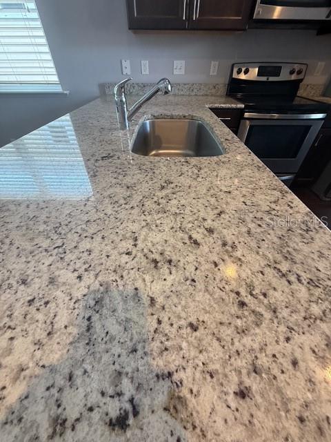 A kitchen island features a granite countertop, an undermount sink, and a chrome faucet — 7925 SW 82ND DRIVE, GAINESVILLE, FL