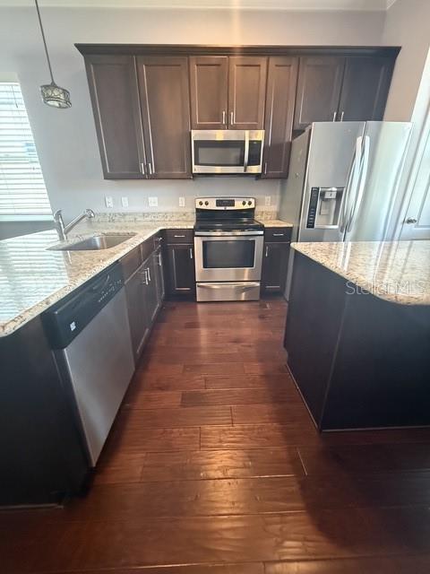 A kitchen features dark wood cabinets, stainless steel appliances, and granite countertops over hardwood floors — 7925 SW 82ND DRIVE, GAINESVILLE, FL