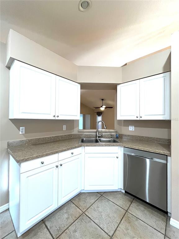 A kitchen features white cabinets, a stainless steel dishwasher, and a double-basin sink — 2160 SUNSTONE DRIVE, LAKELAND, FL