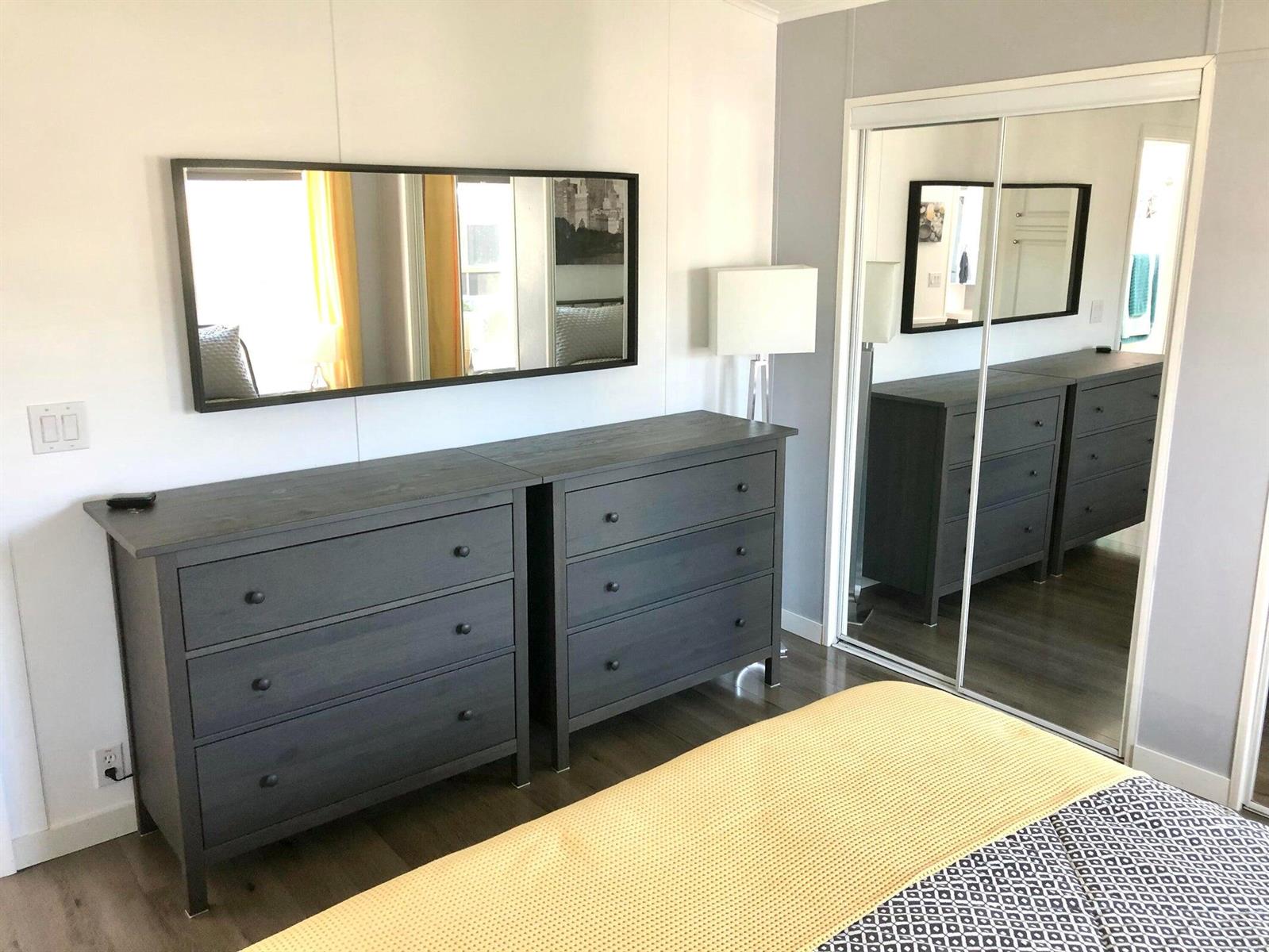 A bedroom features two dark gray wooden dressers, a wall mirror, and mirrored closet doors — 59012 Captiva Bay, Boynton Beach FL 33436, BOYNTON BEACH, FL