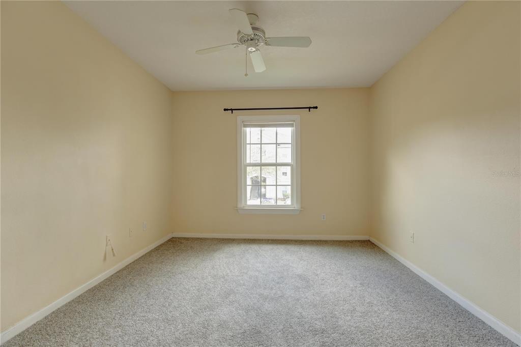 An empty bedroom features beige walls, gray carpeting, a ceiling fan, and a single window — 6566 SWISSCO DRIVE UNIT 425, ORLANDO, FL