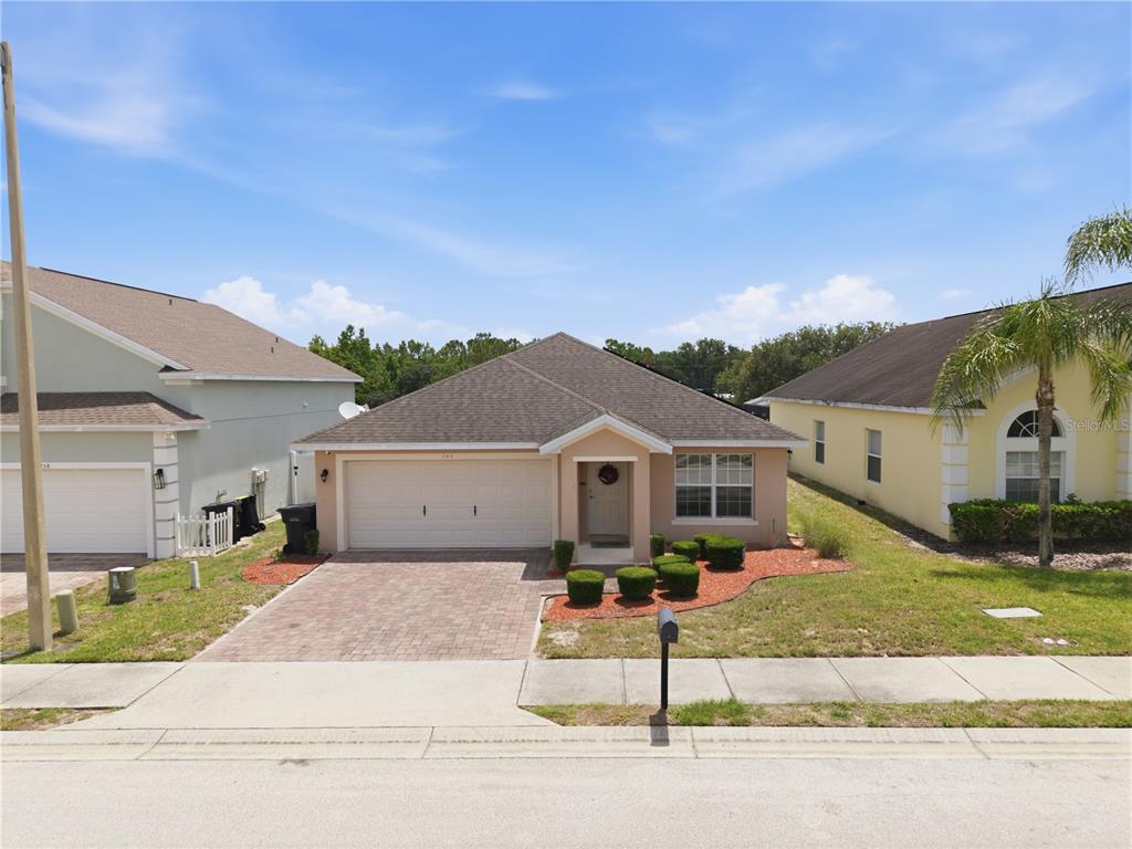 A single-story house with a beige exterior, a two-car garage, and a paved driveway — 248 VICTORY AVENUE, DAVENPORT, FL