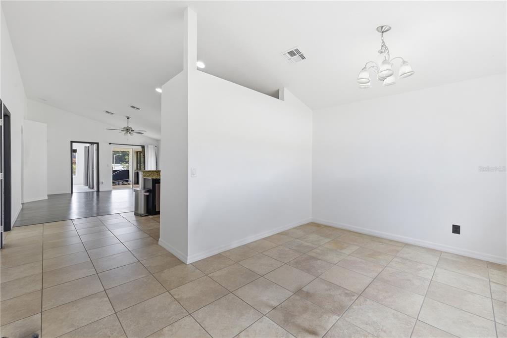 A bright dining area features light-colored tile flooring, white walls, and a decorative chandelier — 248 VICTORY AVENUE, DAVENPORT, FL
