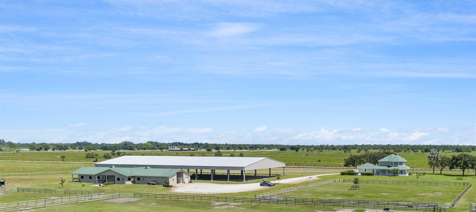 An aerial view shows a large equestrian facility with a barn and a residential house — 13700 SW Groveside Drive, Stuart FL 34997, STUART, FL