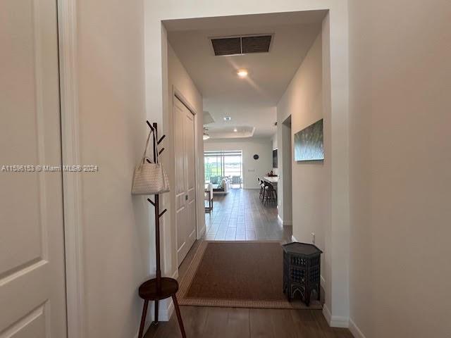 A hallway with a coat rack and small table leads to an open-concept living area — 5545 Hampton Links Ct # 5545, Ave Maria FL 34142, AVE MARIA, FL