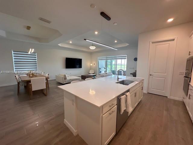 A modern kitchen with a large white island overlooks an open-concept living and dining area — 5545 Hampton Links Ct # 5545, Ave Maria FL 34142, AVE MARIA, FL
