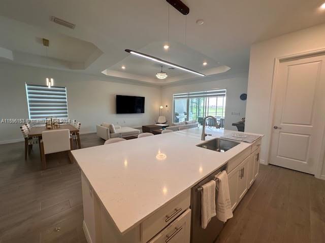 A kitchen island with a white countertop overlooks an open-concept living and dining area — 5545 Hampton Links Ct # 5545, Ave Maria FL 34142, AVE MARIA, FL